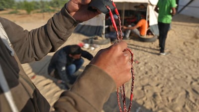 A man prepares a slingshot as Palestinians prepare to demonstrate along the border with the Gaza strip, east of Jabalia. Mohammed Abed / AFP