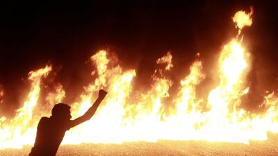 A protester stands near a line of fire during a demonstration in Cairo October 9, 2011. Nineteen people were killed in Cairo on Sunday when Christians, some carrying crosses and pictures of Jesus, clashed with military police, medical and security sources???