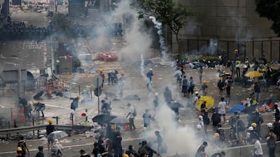 Riot police fire tear gas toward protesters. AP