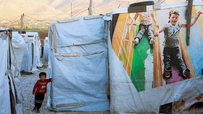 A Syrian refugee child stands outside tents at an informal camp in Deir Zenoun, in the Bekaa valley, Lebanon, in April 2022. Reuters