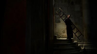 A priest carries a ladder used as a barrier to a chapel during mass at the Church of the Holy Sepulchre, where Jesus Christ is believed to be buried, in the Old City of Jerusalem. AP Photo