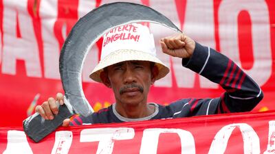 A protester clenches his fist as he marches with thousands of other protester to demand that Philippine president Rodrigo Duterte delivers on a wide range of promises he made in his first state of the nation address last year, from pressing peace talks with Marxist guerrillas, which is currently on hold, to upholding human rights and the rule of law. Bullit Marquez / AP Photo