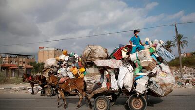 A Palestinian man collects plastic containers on his horse cart in Deir al-Balah in the central of Gaza Strip. Reuters