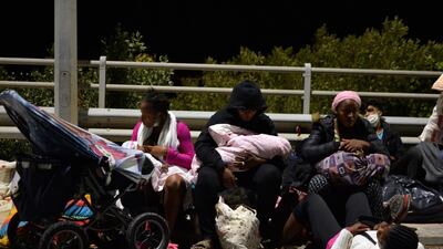 Refugees and migrants with their children gather on a bridge as fire burns at the Moria refugee camp on the northeastern Aegean island of Lesbos, Greece. AP Photo