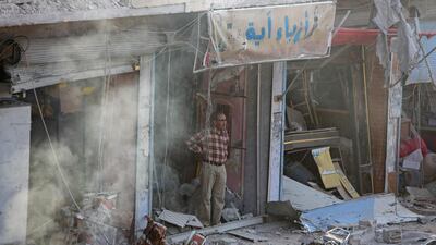 A Syrian man inspects the site of a car bomb explosion. AFP