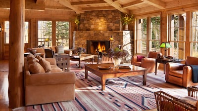 The house boasts floor-to-ceiling windows, traditional timber walls and a native stone chiminea. Photo: Telluride Sotheby's International Realty