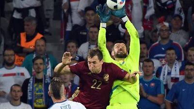 Russia's Artem Dzyuba jumps for the ball with Slovakia goalkeeper Matus Kozacik, right, during the Euro 2016 Group B soccer match between Russia and Slovakia at the Pierre Mauroy stadium in Villeneuve d’Ascq, near Lille, France, Wednesday, June 15, 2016. (AP Photo/Geert Vanden Wijngaert)