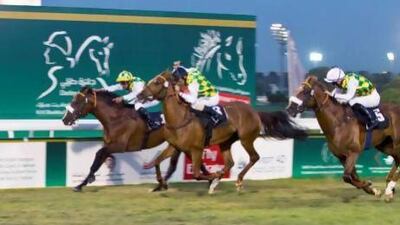 Royston Ffrench, on Rakha, centre, managed to gain ground in the final strides to beat Areem, left, in the Liwa Oasis race. Razan Alzayani / The National