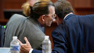 Depp talks to his lawyer in the courtroom. Pool Photo via AP
