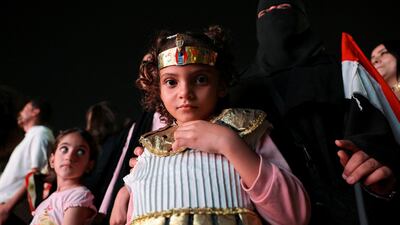 A girl in costume watches the official opening ceremony of the Grand Egyptian Museum on a big screen near Tahrir Square in Cairo. Reuters
