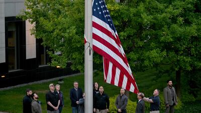 Employees raise the flag outside the US embassy in Kyiv on May 18. AFP