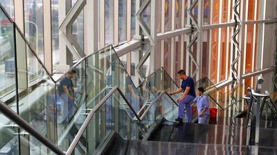 Workers clean glass panels inside a shopping mall in Buenos Aires. Argentina has defaulted on its debt for the second time in 13 years. Enrique Marcarian / Reuters
