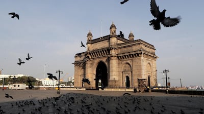 Pigeons fly at a deserted Gateway of India monument in Mumbai, India. AP Photo