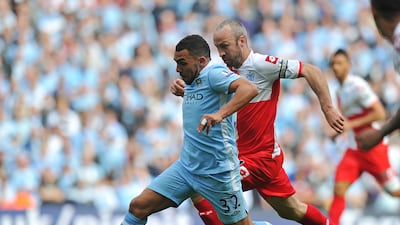Manchester City's Argentinian striker Carlos Tevez battles for the ball with Queens Park Rangers' midfielder Shaun Derry. AFP