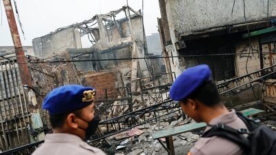 Police stand guard at the scene of a deadly fire at a fuel storage station in Jakarta, Indonesia. Reuters