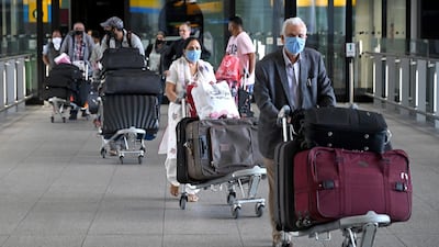 Passengers wear masks as they arrive at Heathrow Airport. EPA