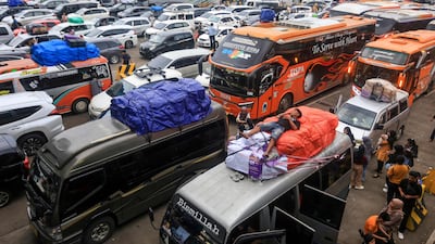 A man falls asleep on top of a vehicle as travellers crowd Merak Port in Cilegon, Indonesia, to celebrate Eid Al Fitr. AFP