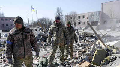 Ukrainian soldiers search for injured people as Ukraine announces death of a fifth Russian general. (Photo by BULENT KILIC / AFP)