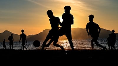 Young people play football on a beach as the sun sets in Banda Aceh, Indonesia. AFP
