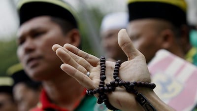 A Muslim man holds a prayer beads while recites a prayer during a protest against the use of the word 'Allah' by Christians, in front of the Court of Appeal in Putrajaya, outside Kuala Lumpur, Malaysia. EPA/Shamshahrin Shamsudin