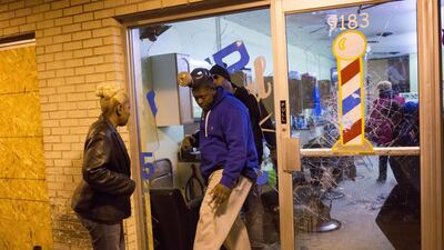 Business owners survey damage during rioting on Monday in Ferguson, Missouri. Aaron P. Bernstein / Getty Images / AFP