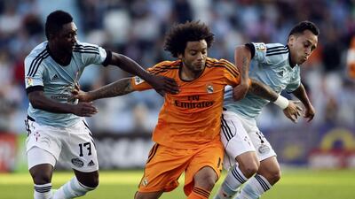 Celta Vigo players Levy Madinda, left, and Fabian Orellana, right, fight for the ball with Real Madrid player Marcelo during their La Liga contest on Sunday. Celta Vigo beat Real Madrid 2-0. Miguel Vidal / Reuters