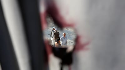 Men are seen through a hole in a window curtain with blood stains at a Shi'ite Muslim mosque after yesterday's attack in Kabul, Afghanistan. Mohammad Ismail / Reuters