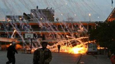 Palestinian civilians and medics run to safety during an Israeli strike over a UN school in Beit Lahia, northern Gaza Strip, today.