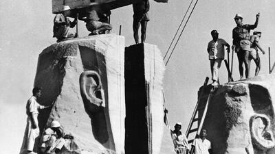 In Egypt, workmen lower one of the heads of the four rock-hewn colossi of King Ramses II into place, on the foundation of the re-sited monument. AP Photo