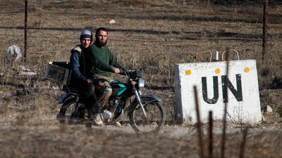 Two Syrian rebels head towards an abandoned UN base between Syria and the Israeli-controlled Golan Heights, in 2016. AP