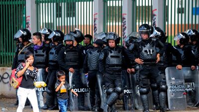 A woman and her son walk past a line of riot police during a protest against Nicaraguan President Daniel Ortega's government in Managua. Oswaldo Rivas/Reuters