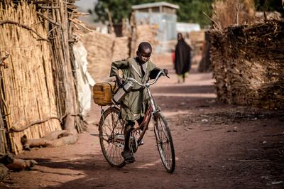 A boy rides a bike near his house at Malkohi refugee camp in Jimeta, Adamawa State, Nigeria. AFP