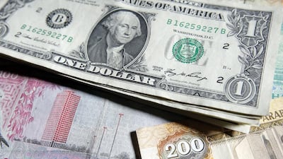 United States dollars with UAE dirhams in the background. The UAE has no plans to depeg its currency. Ryan Carter / The National