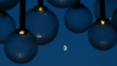The Moon is visible under the lights of the Palazzo del Cinema during the 82nd International Venice Film Festival. AFP