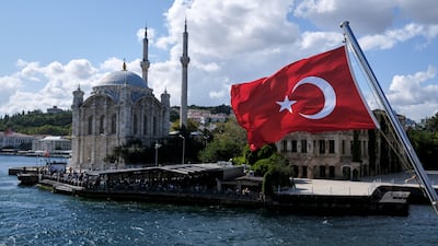 A Turkish flag is pictured on a boat with the Ortakoy Mosque in the background in Istanbul, 'Türkiye'. Reuters
