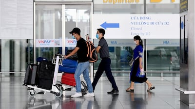 Passengers walk with their luggage at the departure terminal at Noi Bai International Airport in Hanoi on September 16, 2020. AFP.