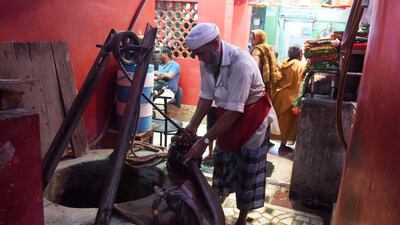 Shakeel Ahmad, one of Old Delhi’s last Bhishtis fills up his goat hide canteen from a well. Dominique Faget / AFP Photo