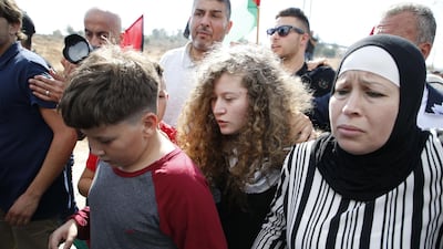 Ahed Tamimi walks with her mother and brother upon her release from prison. AFP
