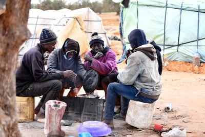 Migrants from Sub-Saharian Africa gather around a fire at a camp in Jebeniana in Tunisia's Sfax governorate on April 24. AFP