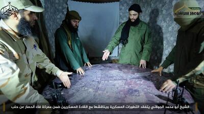 This undated photo shows Jabhat Fatah Al Sham leader Abu Mohammed Jolani, second from right, discussing battlefield details with field commanders over a map in Aleppo. Militant UGC via AP