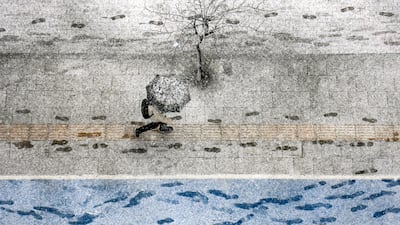 A pedestrian braves the weather in Istanbul. A cold air mass from Siberia, combined with the Altay snowstorm to bring the chilly conditions. AP