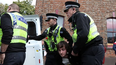 Police officers remove a man arrested for throwing an egg at King Charles III during his visit to York. Reuters