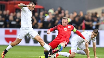 England forward Wayne Rooney, centre, is tackled by Slovakia midfielder Marek Hamsik during the 2018 World Cup match in Trnava on September 4, 2016. Joe Klamar / AFP