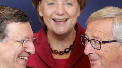 Germany's Chancellor Angela Merkel (centre) smiles as she poses for a family photo next to incoming president of the European Commission Jean-Claude Juncker (right) and outgoing president Jose Manuel Barroso during an EU summit in Brussels on October 23, 2014. European leaders aim to agree a new decade of energy policy to cut climate-warming gas emissions to 2030 at an EU summit on Thursday, but sharp differences over sharing the cost mean a deal will be difficult. Christian Hartmann / Reuters