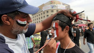 An Iraqi man paints the Iraqi flag on the face of a protester during a protest at Tahrir square in central Baghdad, Iraq, 25 October 2020. EPA