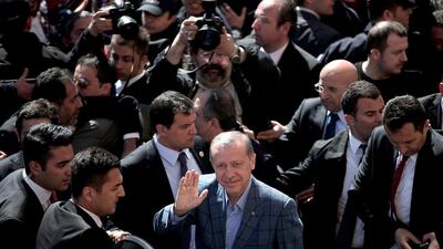 Turkey’s prime minister Recep Tayyip Erdogan, centre, salutes his supporters outside a polling station in Istanbul. Emrah Gurel / AP photo / March 30, 2014