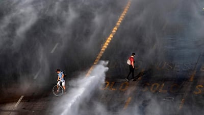 Demonstrators are sprayed by a riot police water cannon during clashes in Santiago, Chile. AFP