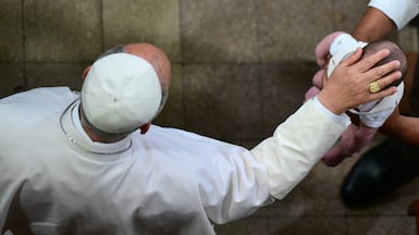 Pope Leo XIV blesses a baby as he arrives to meet charity and welfare organisations at the Church of Sant Agusti in Montserrat. AFP