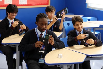 Children at the Gems Winchester School, Dubai use pouches that keep the phones locked away during school time. Chris Whiteoak / The National