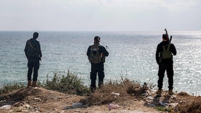 Fighters loyal to the interim Syrian government of President Ahmad Al Shara look out over the Mediterranean Sea from Latakia on Sunday. AFP